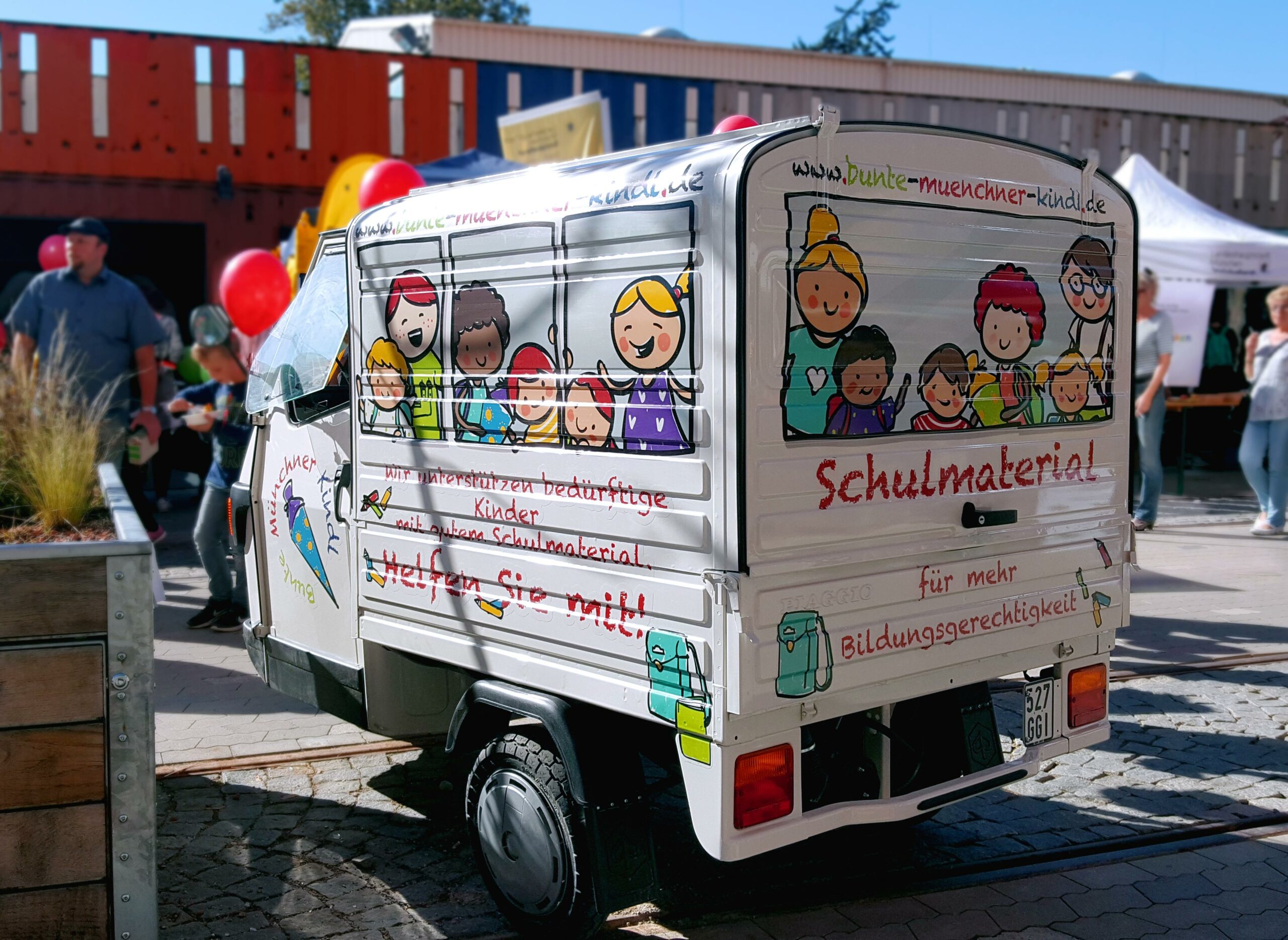 Foto eines mit Illustrationen beklebten Fahrzeugs als Werbemittel für Bunte Münchner Kindl in München. Die bunten Illustrationen geben dem Fahrzeug den Look eines mit Kindern besetzten Schulbusses.