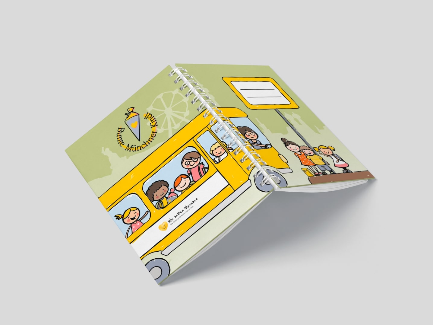 Mockup mit der Umschlagsdoppelseite des nachhaltigen Hausaufgabenheft Bunte Münchner Kindl München, auf dem Umschlag ist ein großer gelber Bus und Kinder illustriert, auf hellgrünem Hintergrund, mit Logo und Namensfeld auf Vorder-und Rückseite