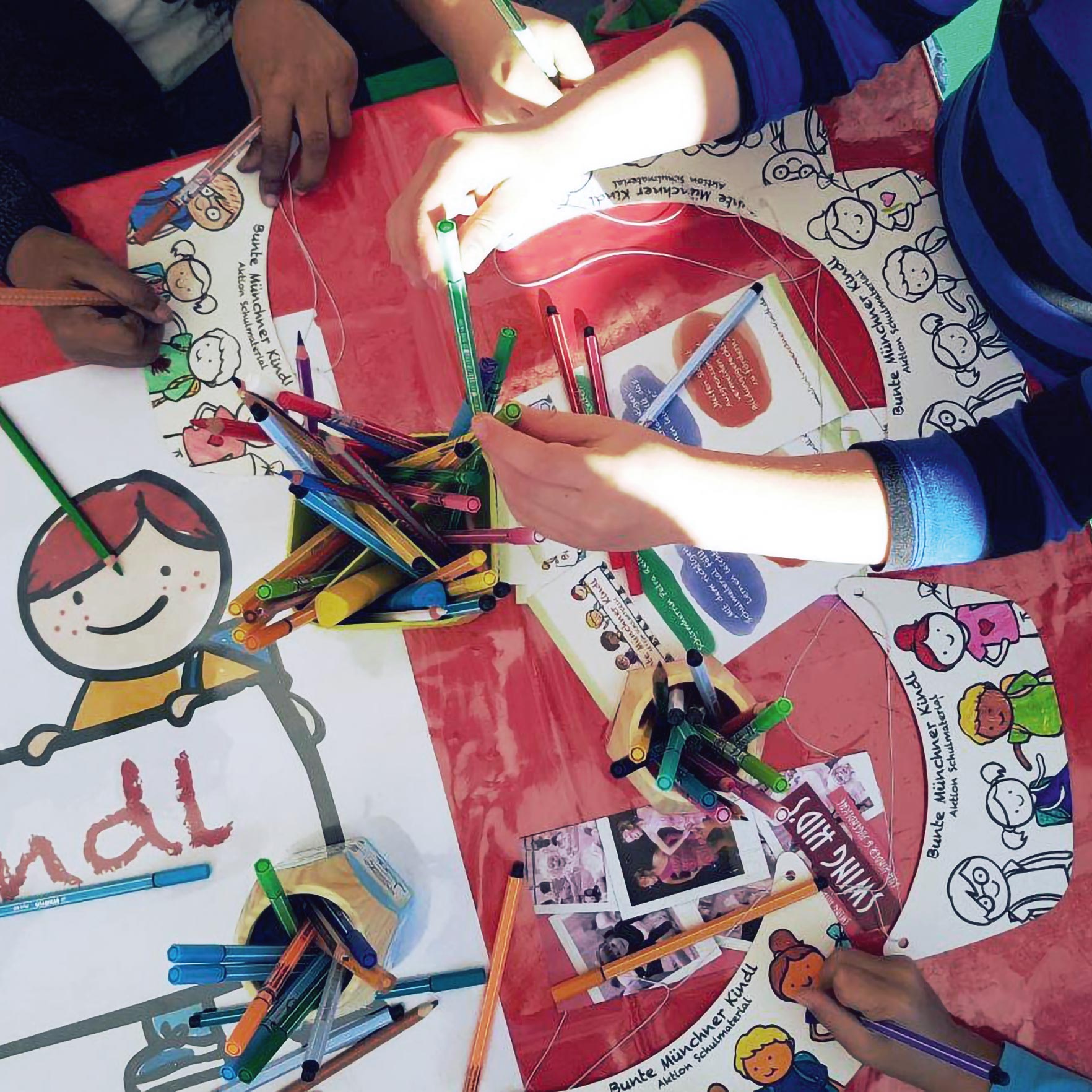 Die illustrierte Sonnencap, ist selbst von den Kindern gestaltbar, an dem Tisch malen Kinder ihre eigenen Caps